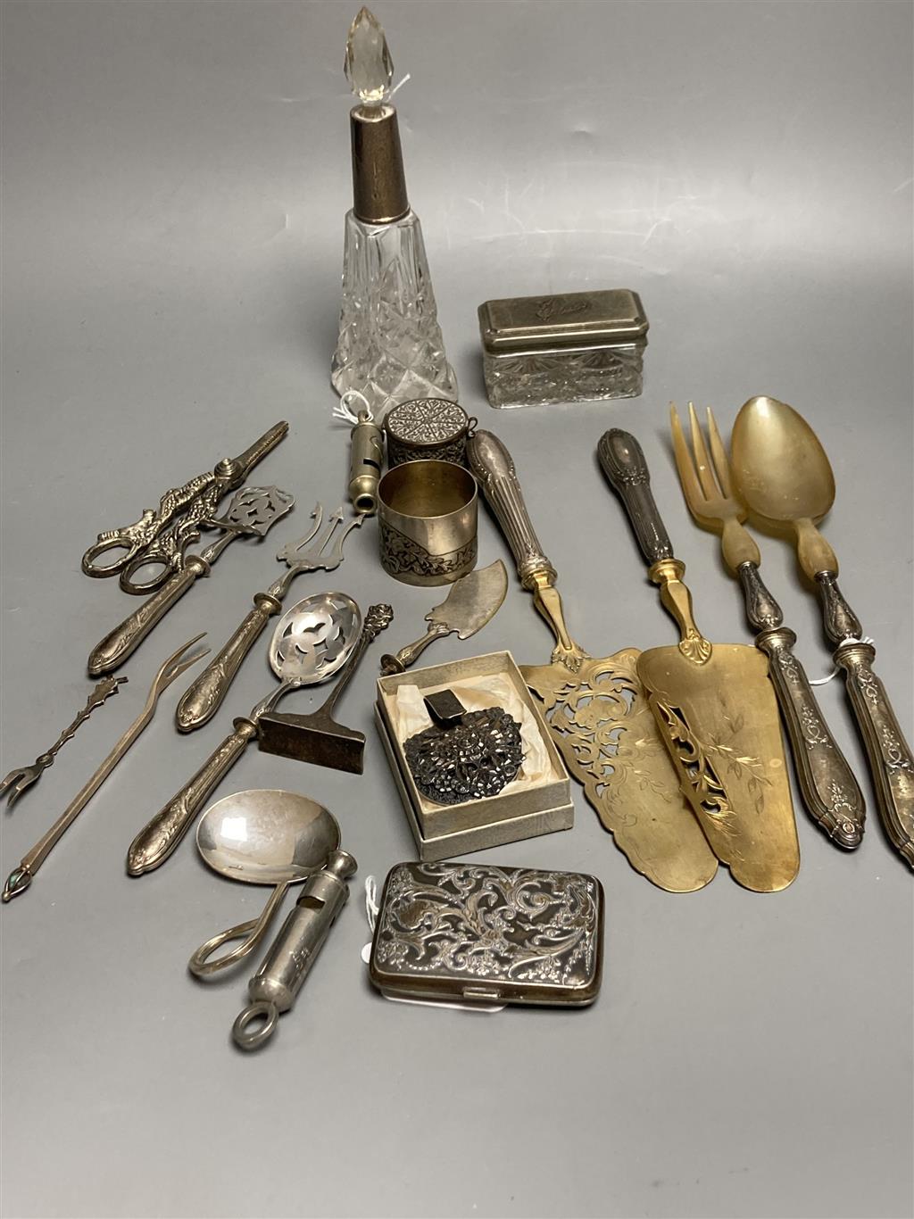 Two plated whistles, Acme and Metropolitan, a white metal embossed cigarette case and sundry items,